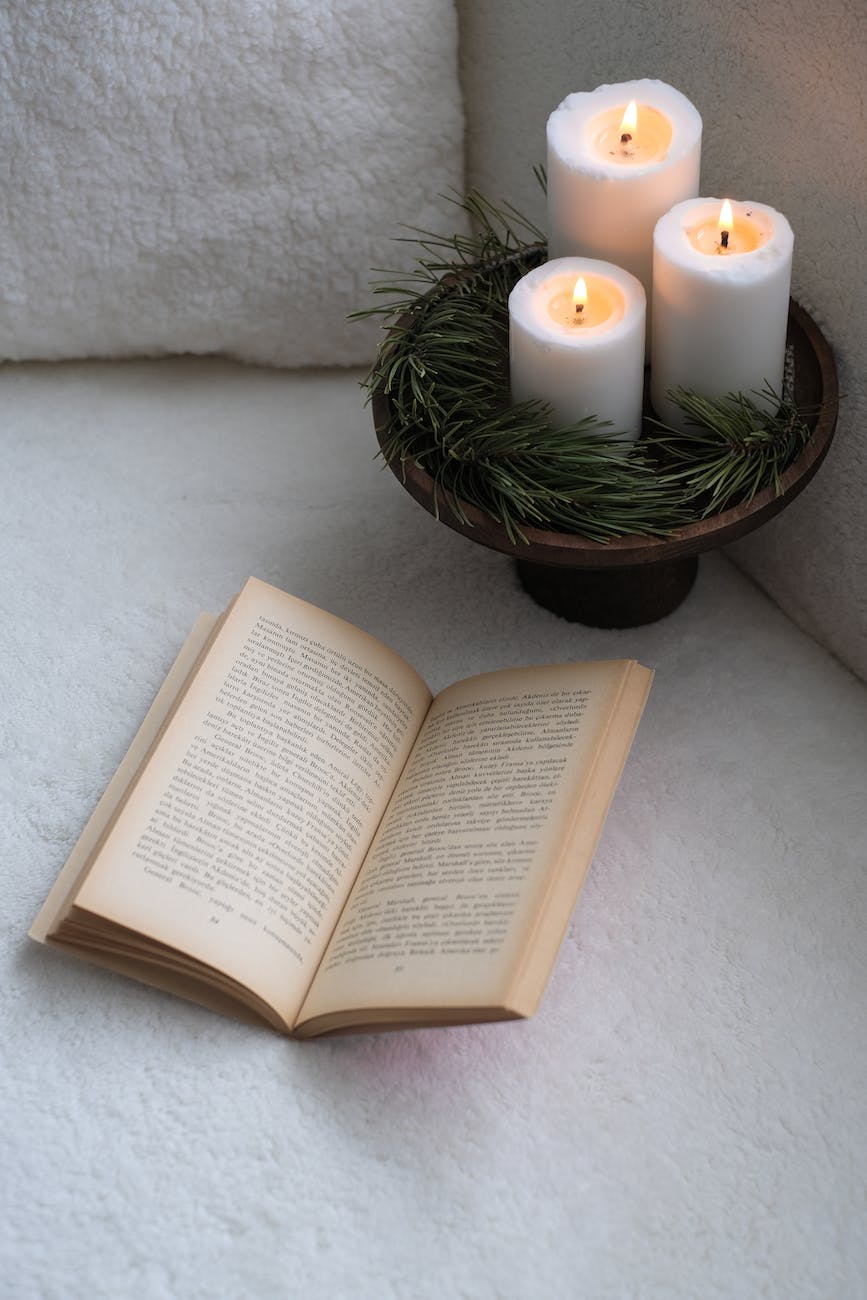 tray with burning candles and a book on the sofa